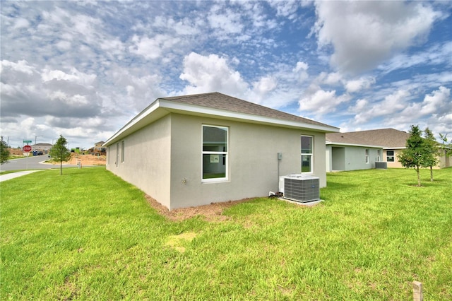 rear view of property featuring a yard and central AC