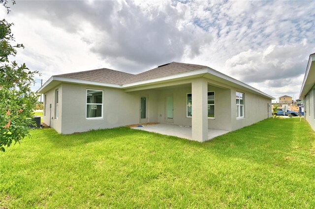 rear view of property featuring a lawn and a patio area