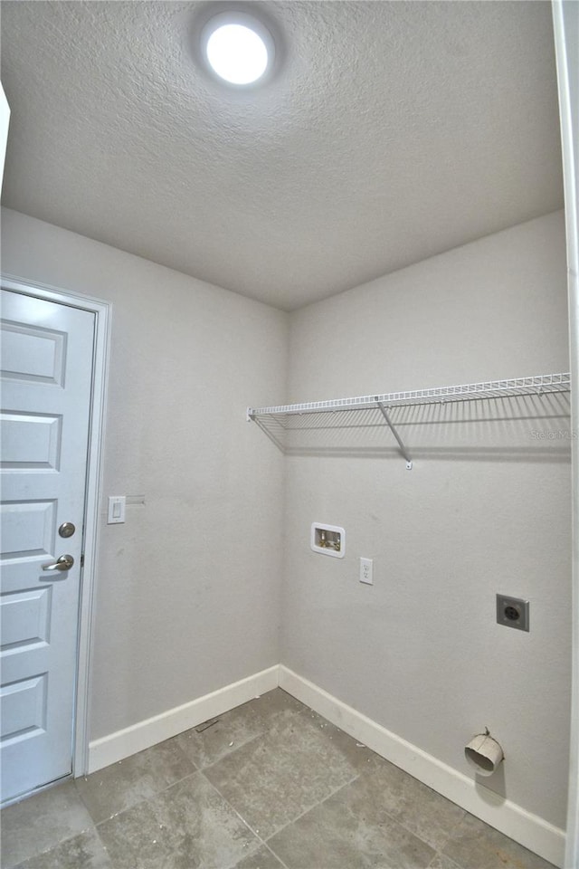 laundry area with hookup for a washing machine, a textured ceiling, electric dryer hookup, and tile flooring