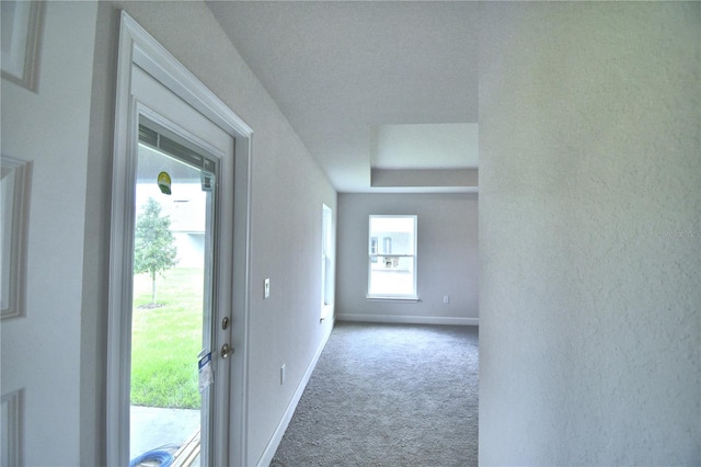 corridor featuring light carpet and a textured ceiling