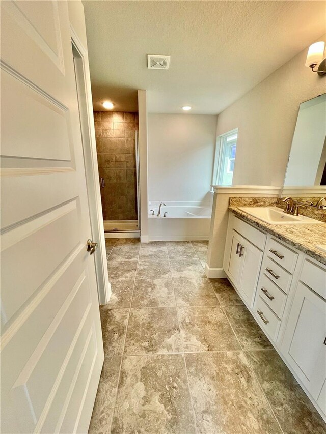 bathroom featuring vanity, tile flooring, a textured ceiling, and shower with separate bathtub