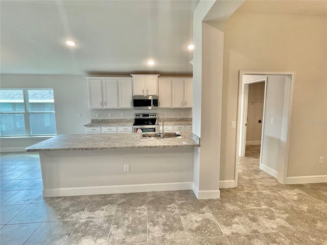 kitchen with stainless steel appliances, light tile flooring, sink, white cabinets, and light stone counters