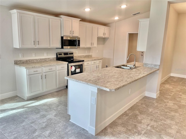 kitchen featuring white cabinets, light tile floors, appliances with stainless steel finishes, and sink