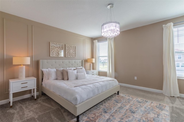 bedroom with an inviting chandelier and dark colored carpet