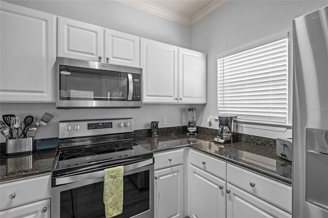 kitchen featuring crown molding, white cabinets, appliances with stainless steel finishes, and dark stone countertops