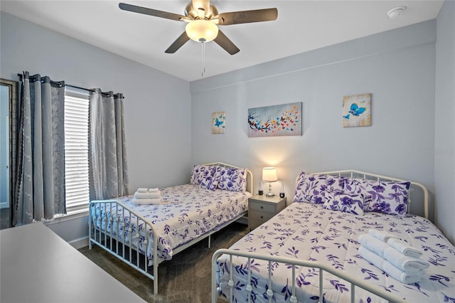 bedroom featuring dark colored carpet, ceiling fan, and multiple windows