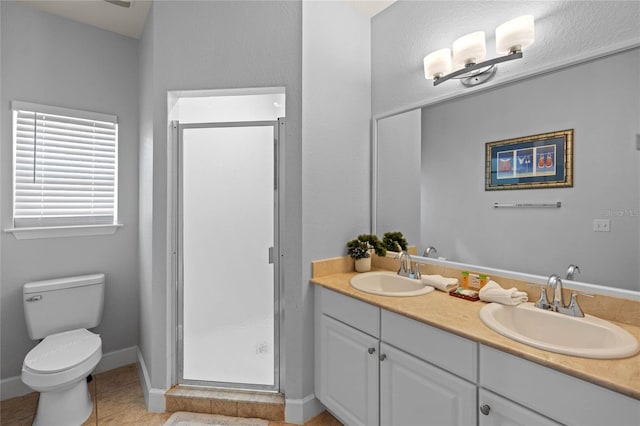 bathroom featuring tile floors, double vanity, a shower with shower door, and toilet