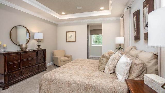 carpeted bedroom with crown molding and a tray ceiling