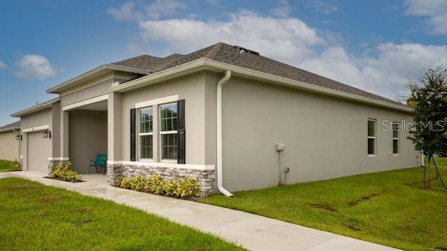 view of home's exterior with a garage and a lawn