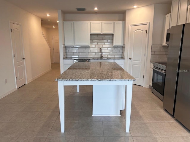 kitchen featuring a kitchen island, white cabinetry, appliances with stainless steel finishes, and sink