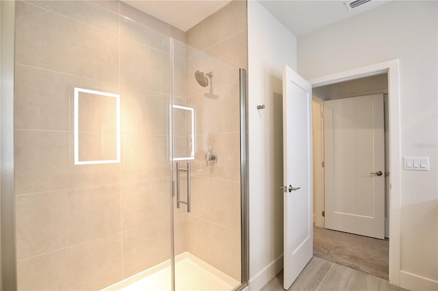 bathroom featuring walk in shower and hardwood / wood-style flooring