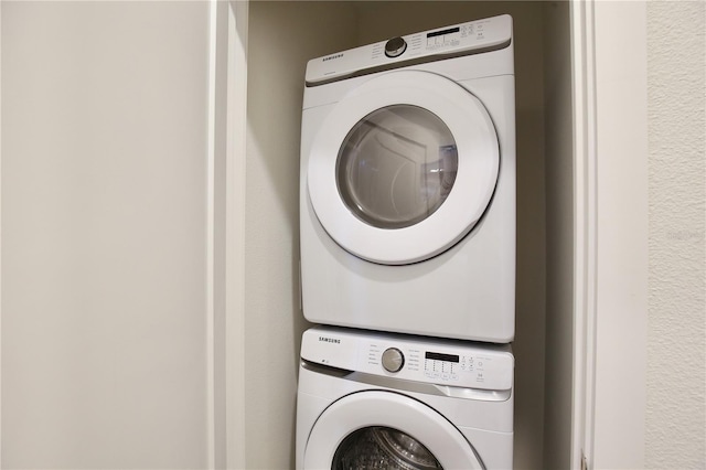 clothes washing area with stacked washer and dryer