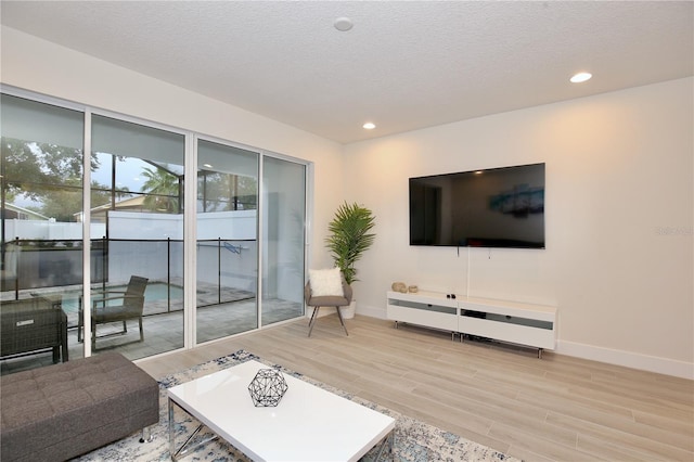 living room featuring a textured ceiling and light hardwood / wood-style floors