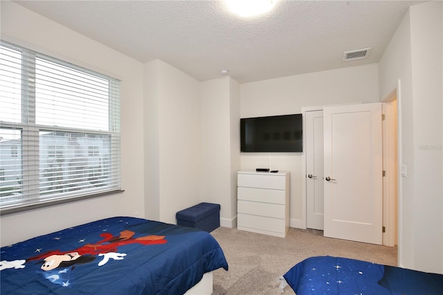 carpeted bedroom with a textured ceiling