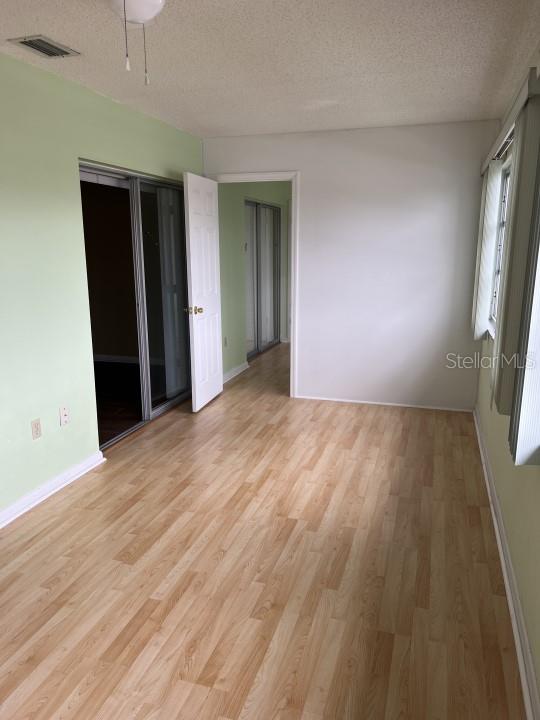 empty room featuring a textured ceiling and light wood-type flooring