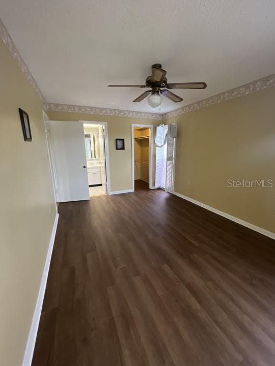 unfurnished room with ceiling fan and dark hardwood / wood-style flooring