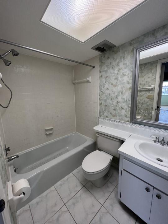 full bathroom featuring vanity, toilet, and tiled shower / bath