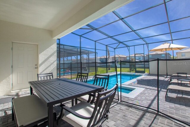 view of swimming pool with a patio area and glass enclosure