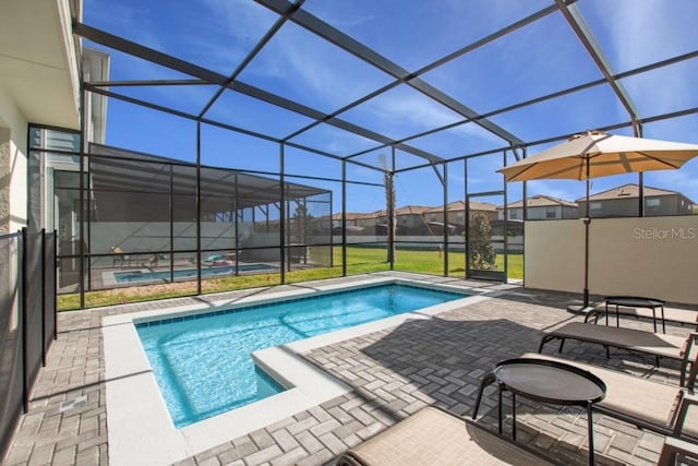 view of swimming pool with a patio area and a lanai