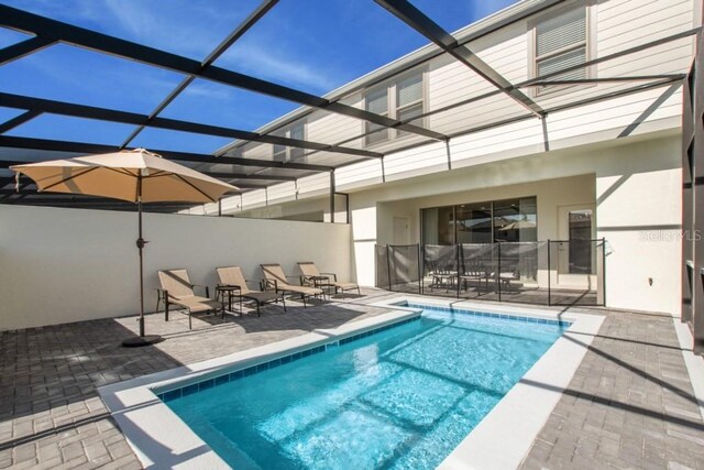 view of swimming pool featuring glass enclosure and a patio area