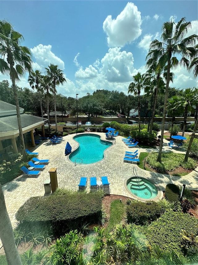 view of pool with a hot tub and a patio area