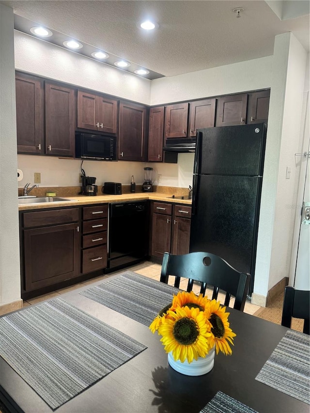 kitchen featuring a textured ceiling, black appliances, dark brown cabinetry, and sink