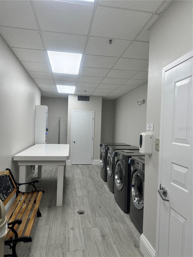 washroom featuring washing machine and clothes dryer and light hardwood / wood-style flooring