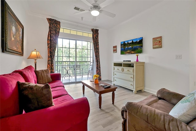 living room featuring ceiling fan, light wood-type flooring, and crown molding