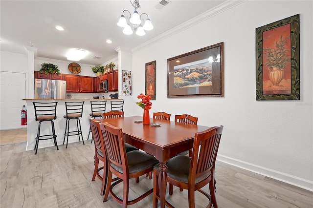 dining area featuring light wood-type flooring, a notable chandelier, and ornamental molding