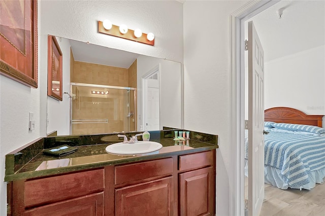 bathroom featuring a shower with door, vanity, and hardwood / wood-style floors