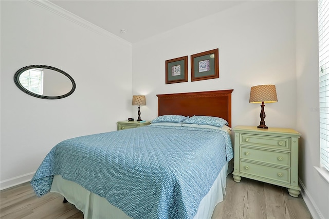 bedroom featuring light hardwood / wood-style floors, multiple windows, and ornamental molding