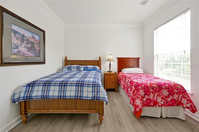 bedroom with light hardwood / wood-style flooring and ornamental molding