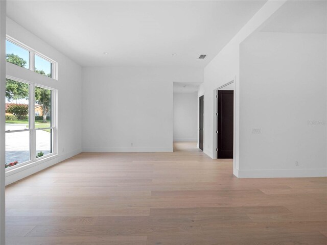 spare room featuring visible vents, baseboards, and light wood-type flooring