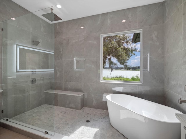 full bathroom with recessed lighting, a freestanding bath, tile walls, and a tile shower