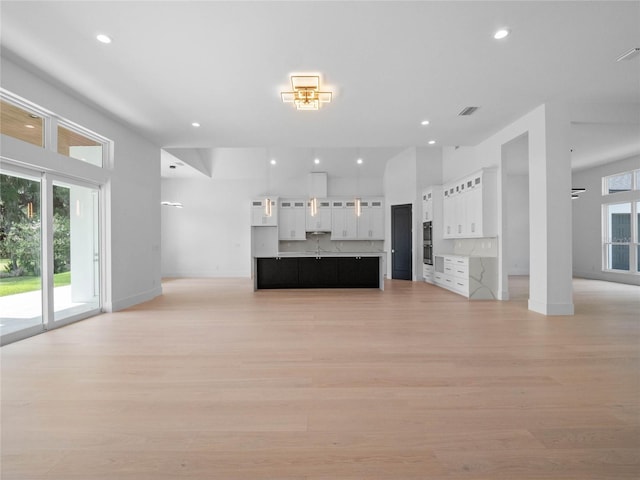 unfurnished living room with light wood-style flooring, plenty of natural light, and recessed lighting