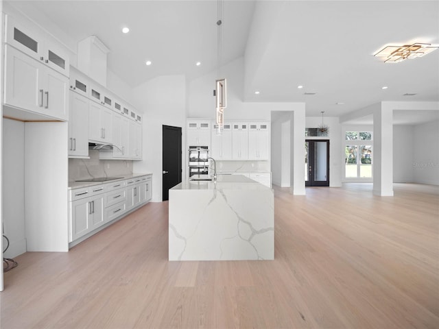 kitchen with white cabinetry, light wood-style floors, black electric stovetop, and a sink