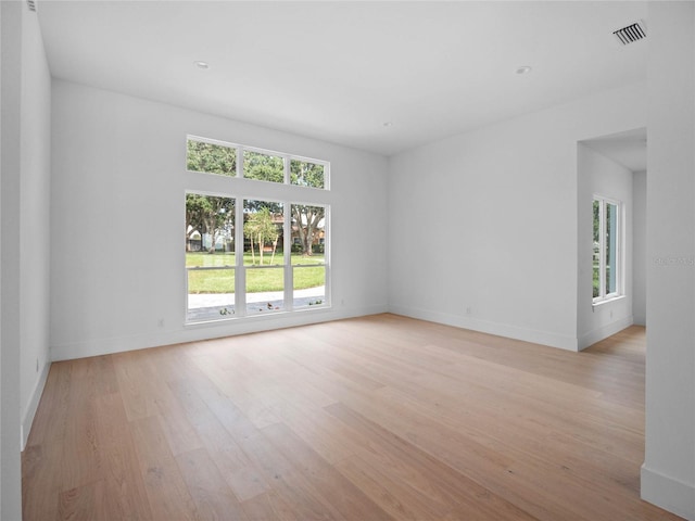 unfurnished room featuring visible vents, baseboards, and light wood-style floors