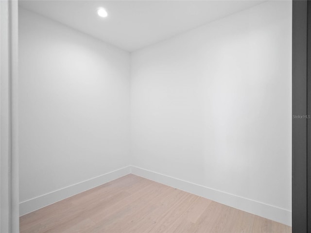 empty room featuring recessed lighting, light wood-type flooring, and baseboards