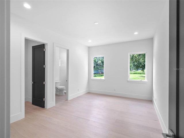 unfurnished bedroom with light wood finished floors, recessed lighting, connected bathroom, and baseboards