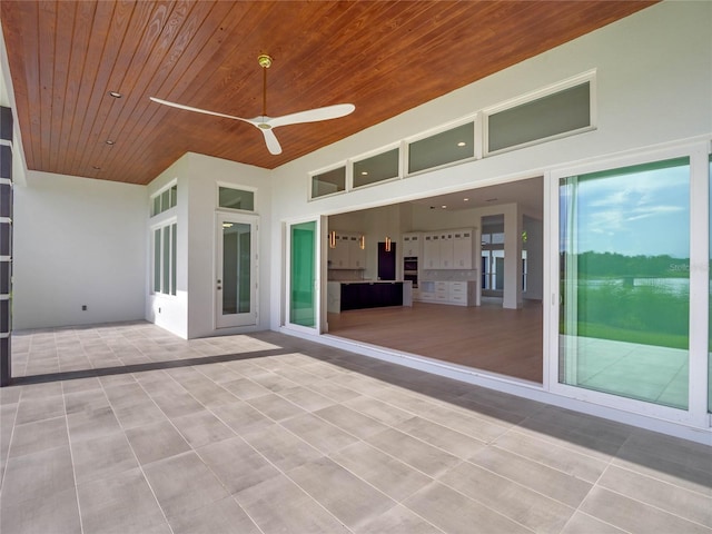 view of patio with ceiling fan and a water view