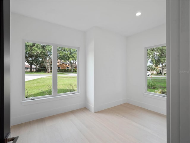 empty room with recessed lighting, baseboards, and wood finished floors