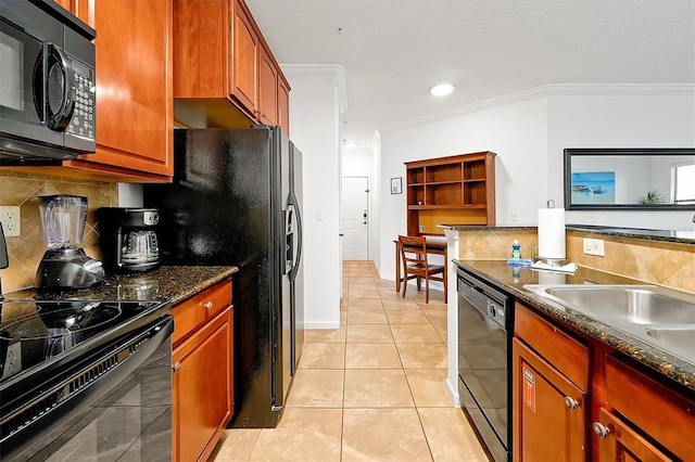 kitchen with light tile patterned floors, tasteful backsplash, ornamental molding, black appliances, and dark stone counters