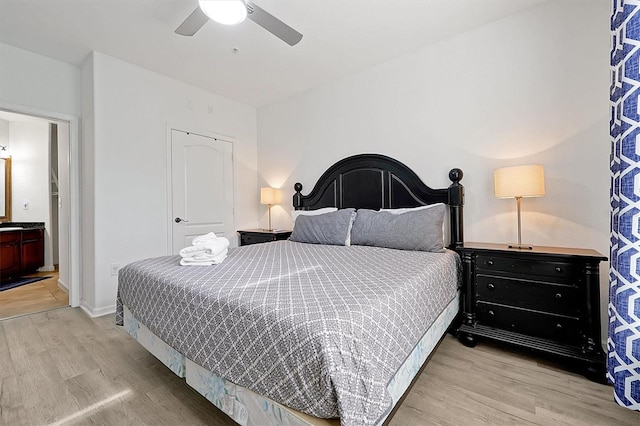 bedroom featuring connected bathroom, light hardwood / wood-style floors, and ceiling fan