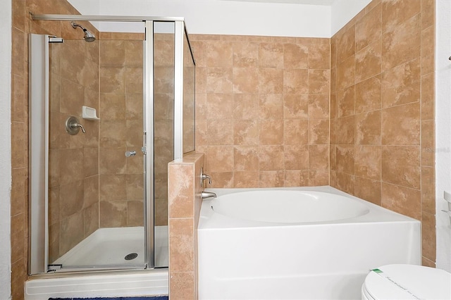 bathroom featuring toilet and separate shower and tub