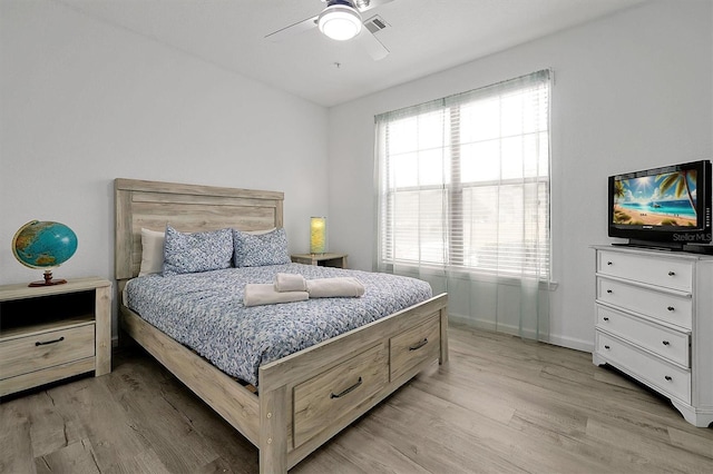 bedroom with multiple windows, light hardwood / wood-style floors, and ceiling fan