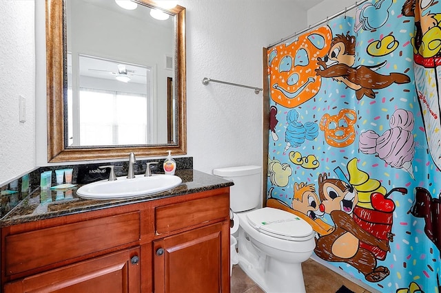 bathroom with vanity, ceiling fan, walk in shower, toilet, and tile patterned floors