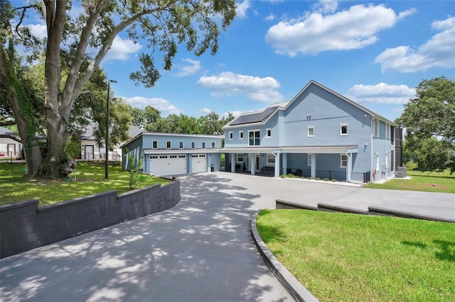 view of front of house with a garage, central air condition unit, and a front lawn