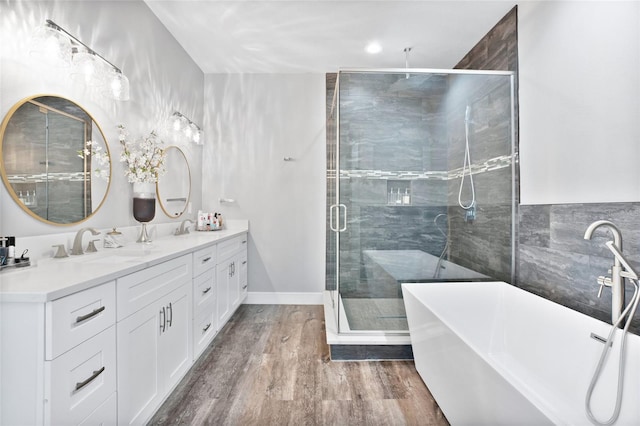 bathroom with wood-type flooring, shower with separate bathtub, and double sink vanity