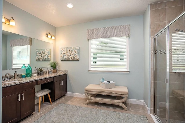 bathroom with tile patterned flooring, an enclosed shower, and vanity