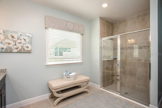 bathroom featuring vanity, an enclosed shower, tile patterned flooring, and a textured ceiling